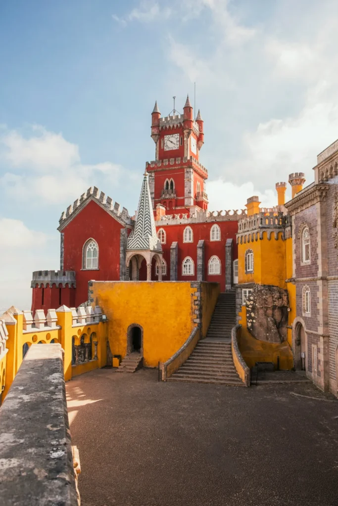 Red clock tower and yellow walls of Pena Palace in Sintra